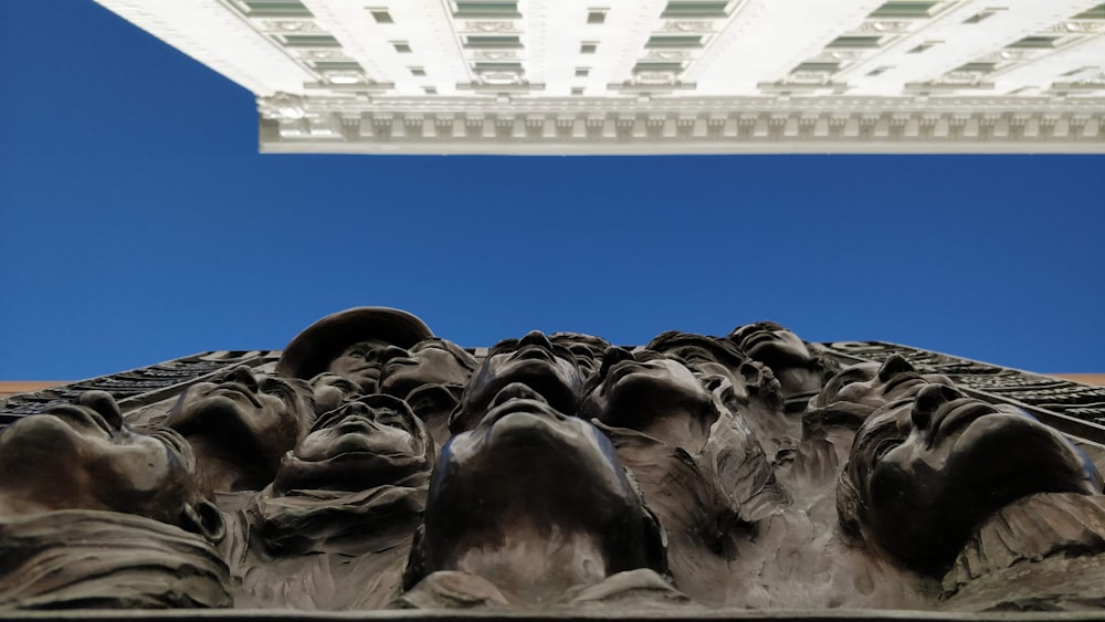 a sculpture of a group of people with a building in the background