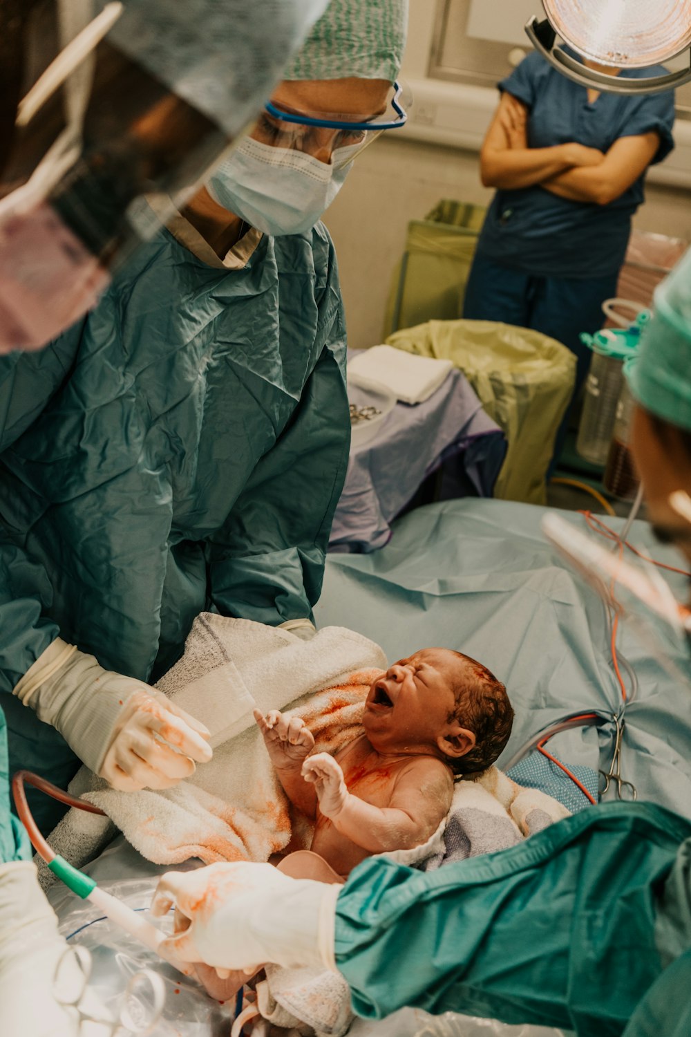 ein Baby in einem Krankenhausbett mit medizinischem Personal um sich herum