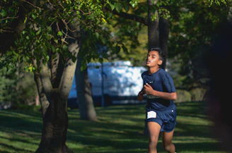 A young person jogging in a park wearing smart fitness gear with a smartwatch tracking vitals.