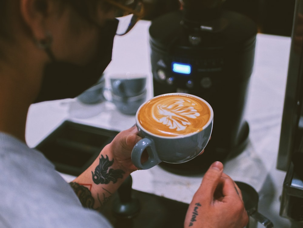 a person is holding a cup of coffee