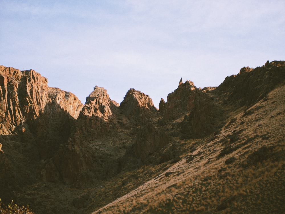 a view of a mountain range from the bottom of a hill