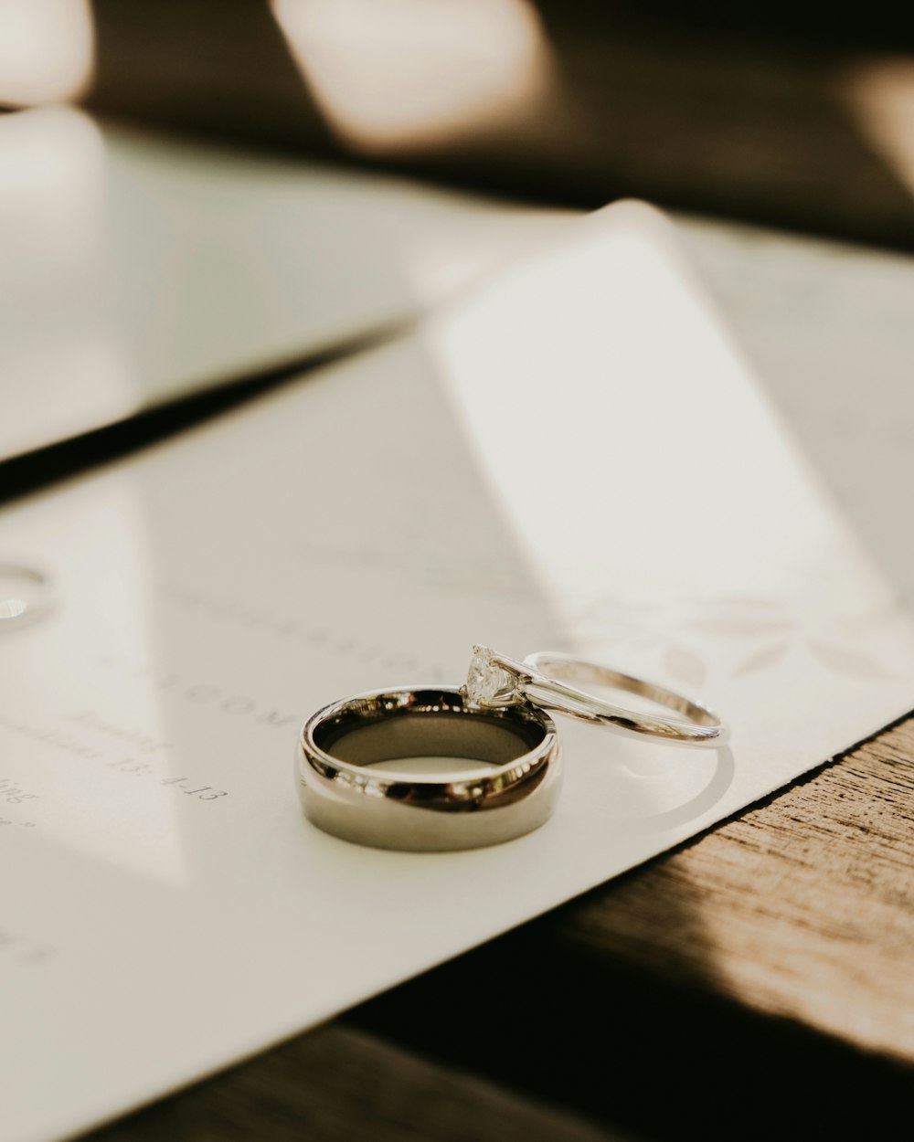 two wedding rings sitting on top of a piece of paper