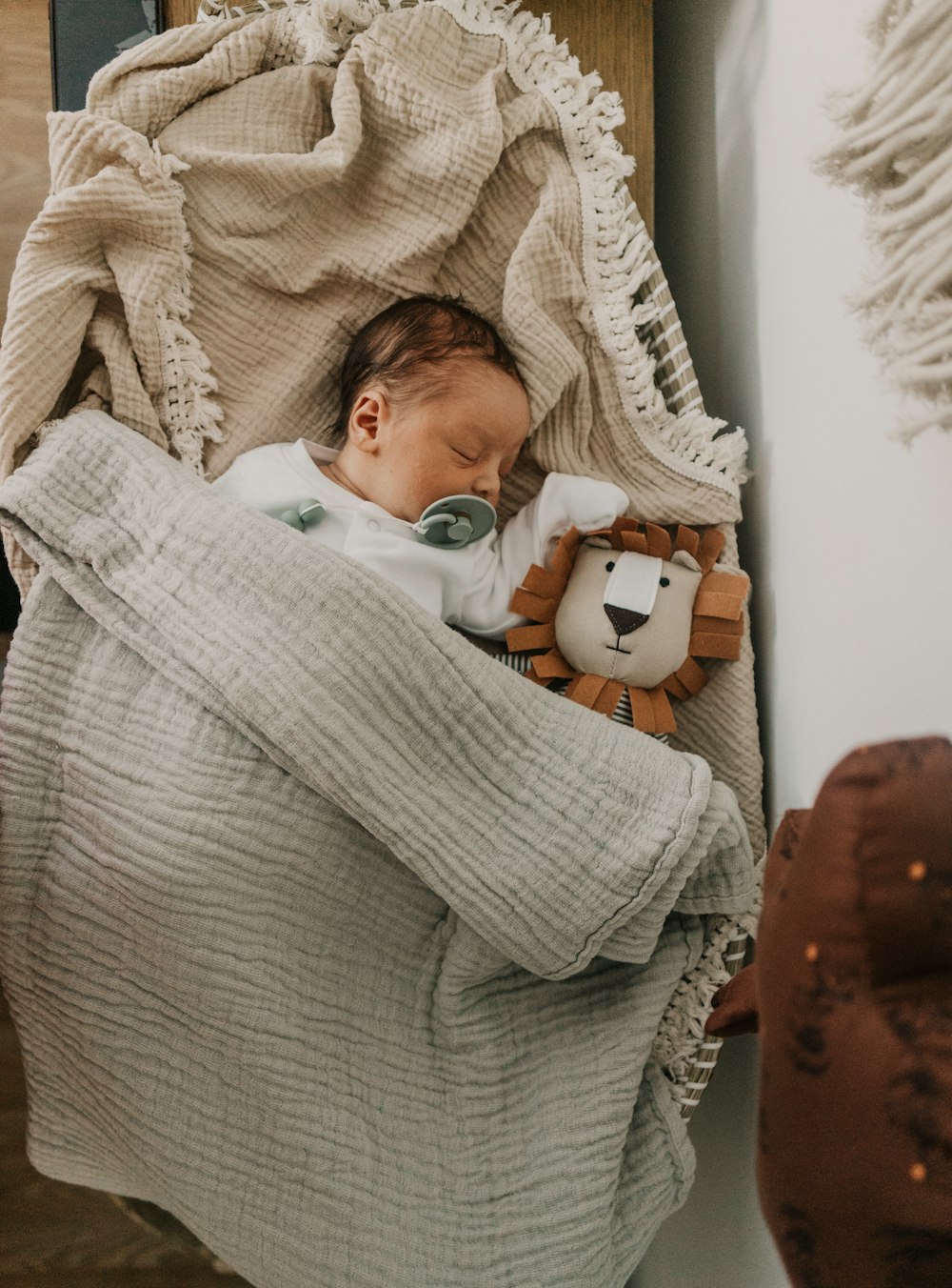 a baby sleeping in a bed with a stuffed animal