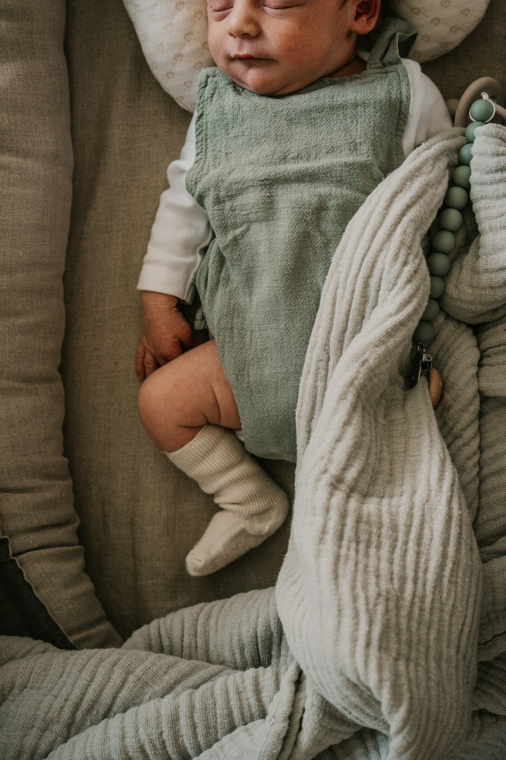 a baby sleeping on a couch with a blanket