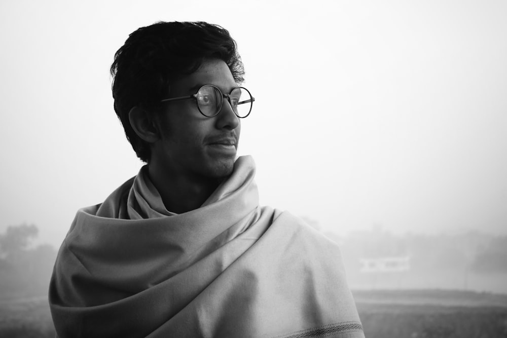 a man wearing glasses and a shawl