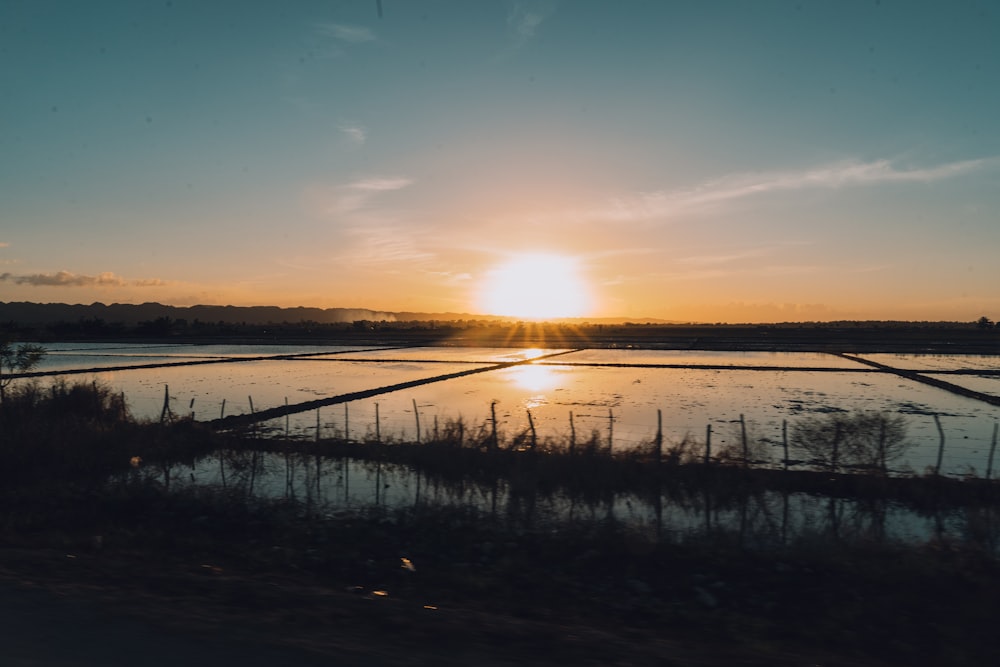 the sun is setting over a body of water