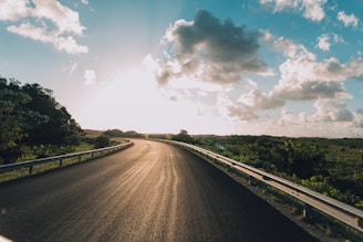 the sun is shining down on the road