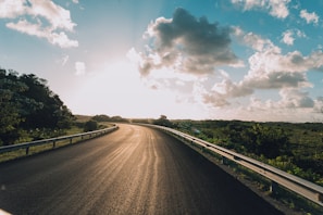 the sun is shining down on the road