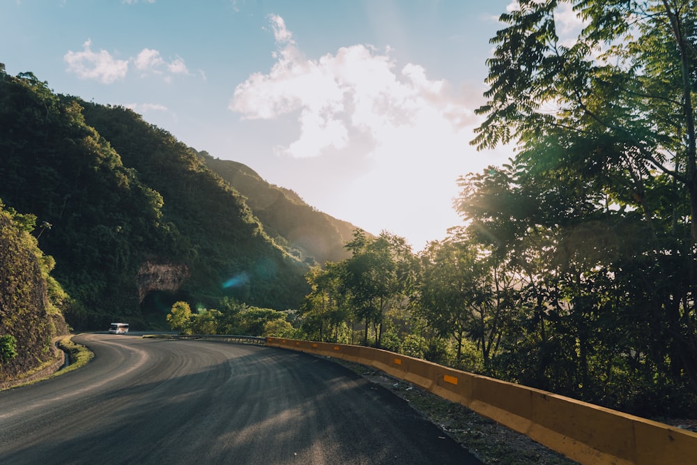 the sun shines on a winding road in the mountains