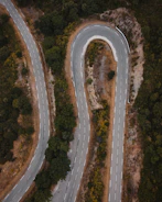 Abstract aerial view of winding roads through green hills.