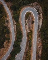 An aerial view of a winding road through scenic countryside.