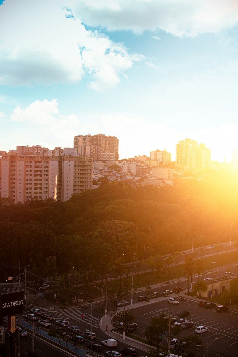 the sun is setting over a city with tall buildings