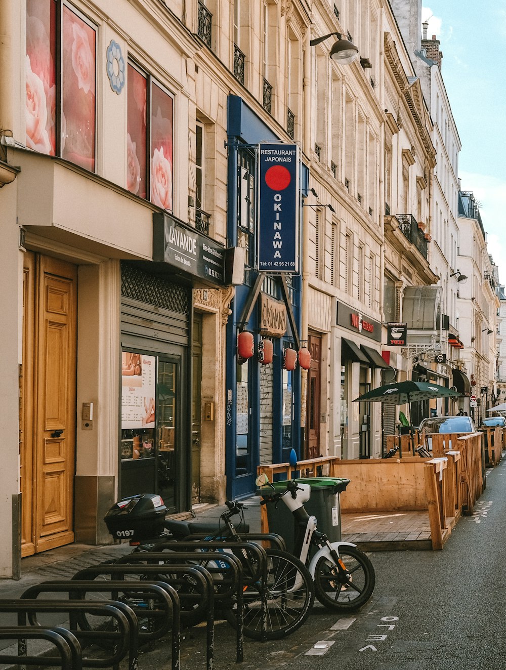 a row of parked bikes sitting on the side of a street