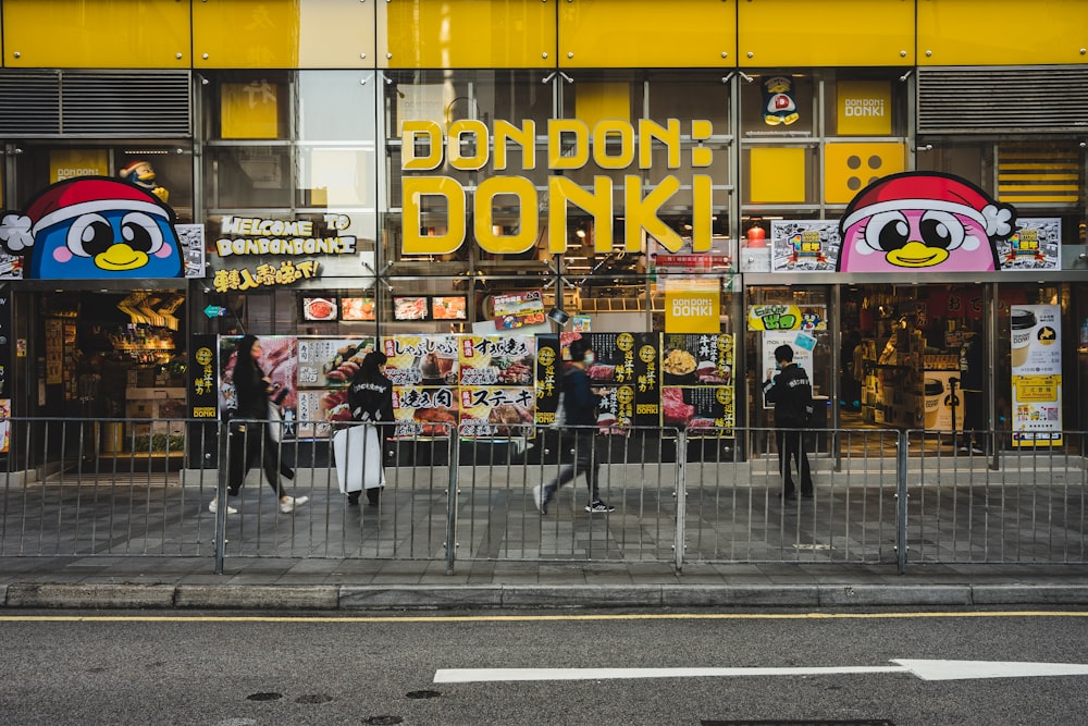 une devanture de magasin avec des gens qui passent sur le trottoir