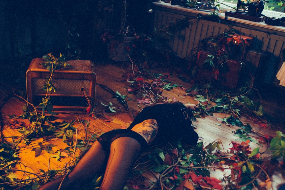 a woman laying on the floor surrounded by leaves