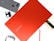 A red Samsung Chromebook laptop is positioned centrally with its brand name visible. Surrounding it are various tech accessories, including a smartphone with a fabric cover, a pair of wireless earbuds, a smart watch, and a stylus pen.