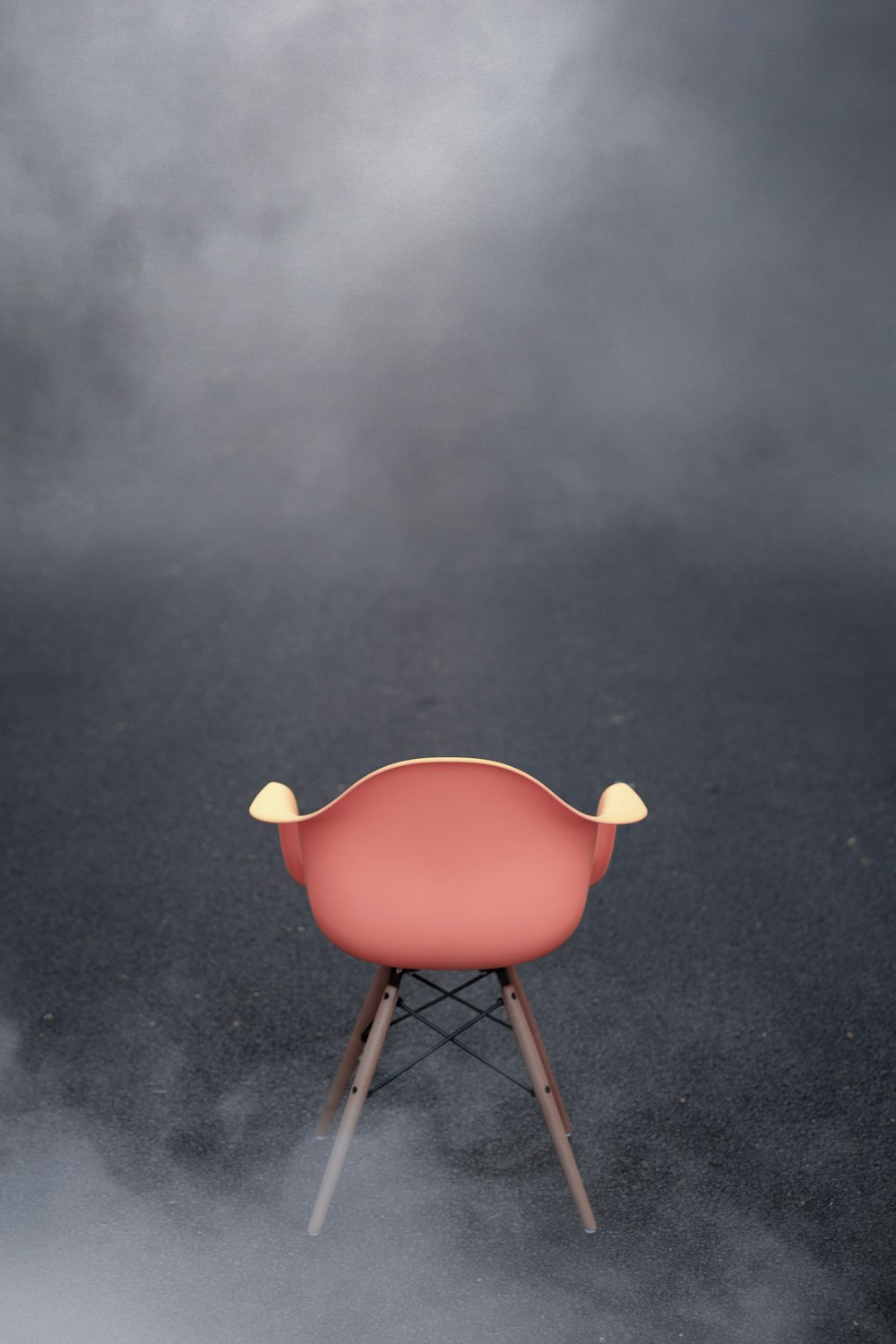 a pink chair sitting on top of a cloud filled floor