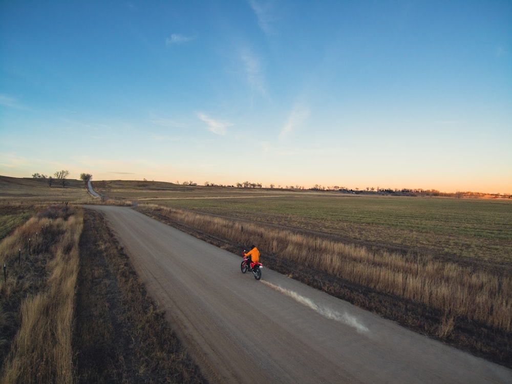 a person riding a bike down a dirt road