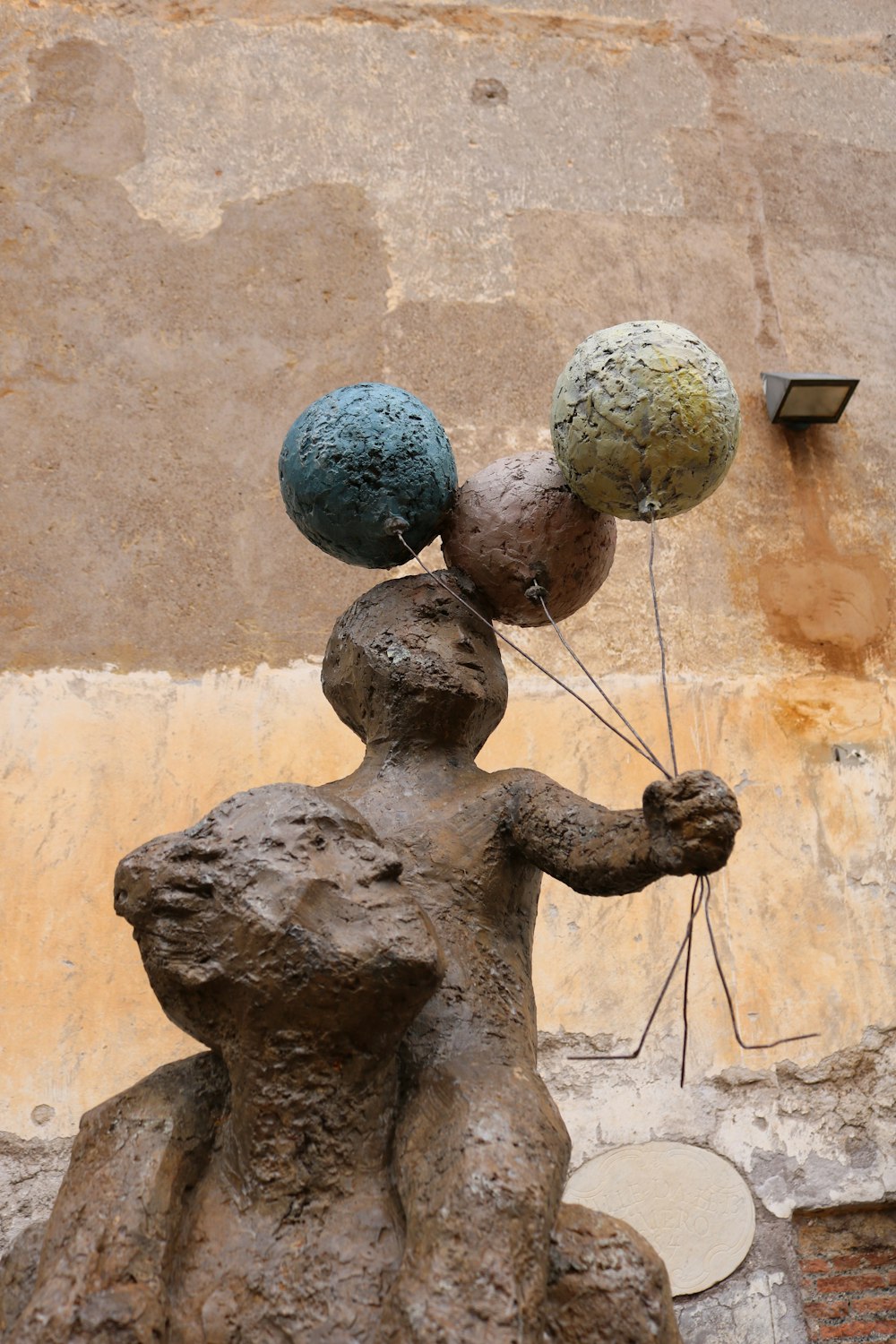 a statue of a person holding two balls