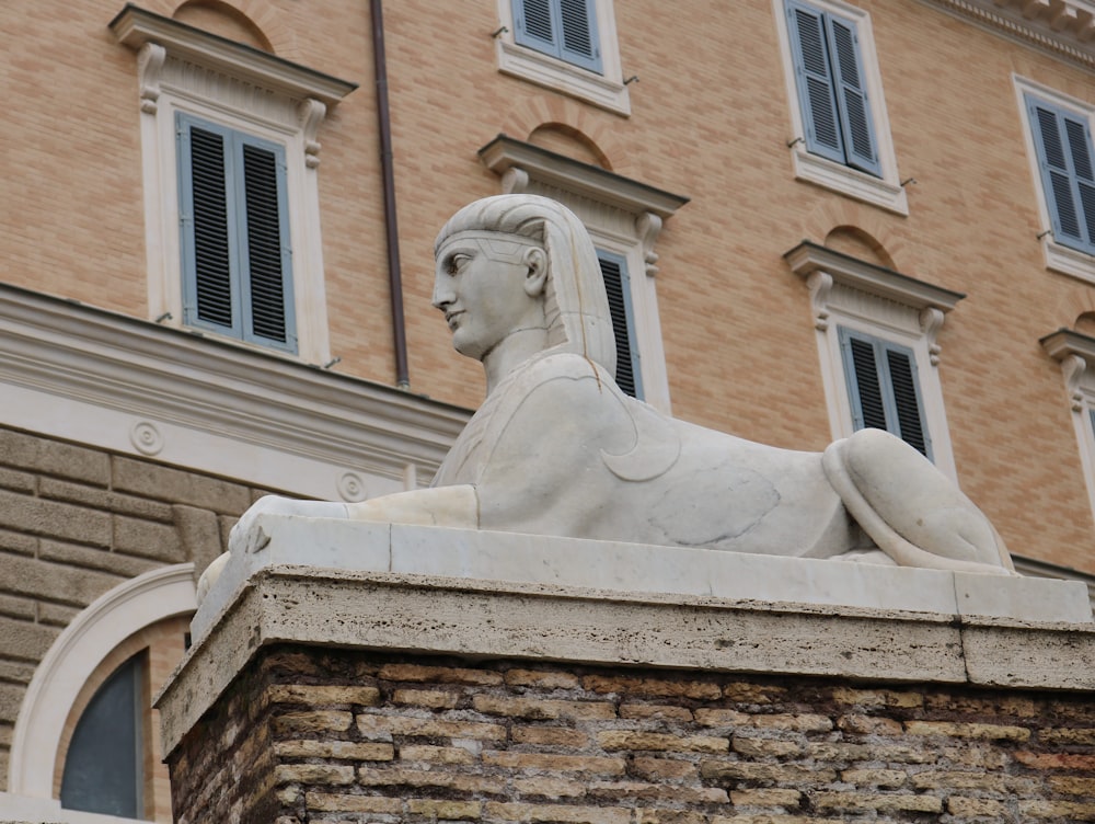 a statue of a woman sitting on top of a building