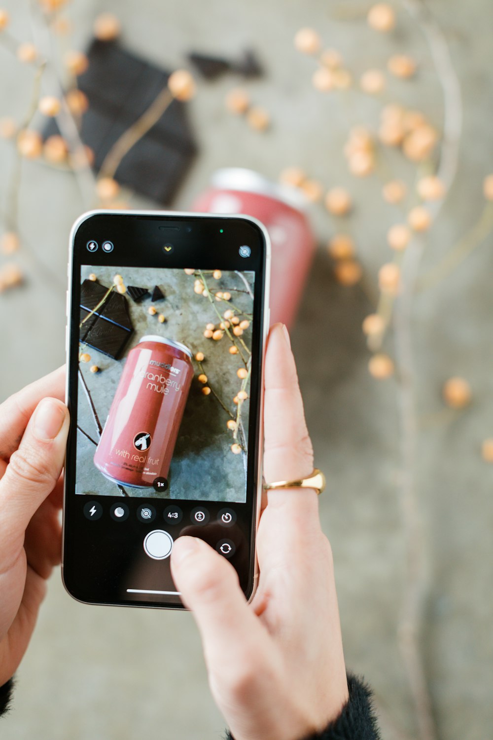 a person taking a picture of a red can