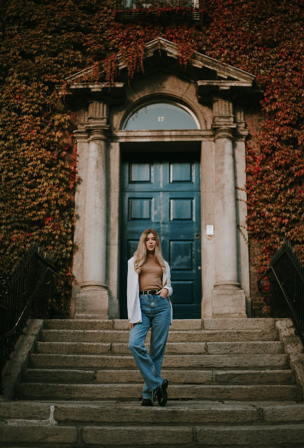uma mulher em pé na frente de uma porta azul