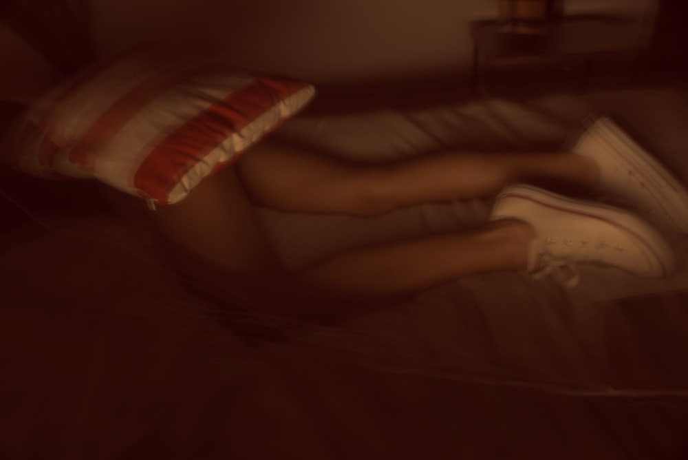 une personne allongée sur un lit avec un oreiller
