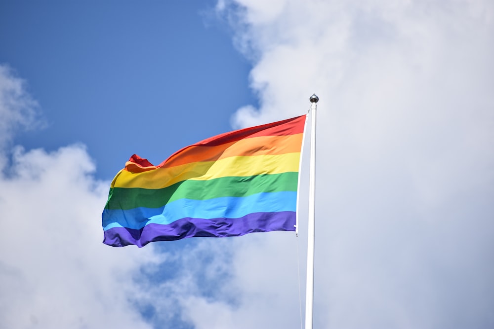 a rainbow flag flying high in the sky