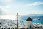 a windmill in the middle of a town by the ocean