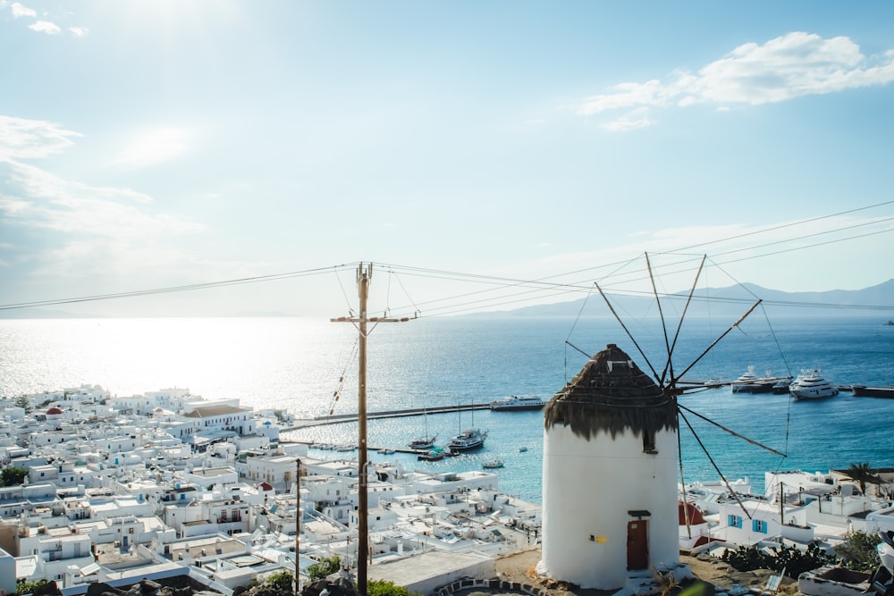 a windmill in the middle of a town by the ocean