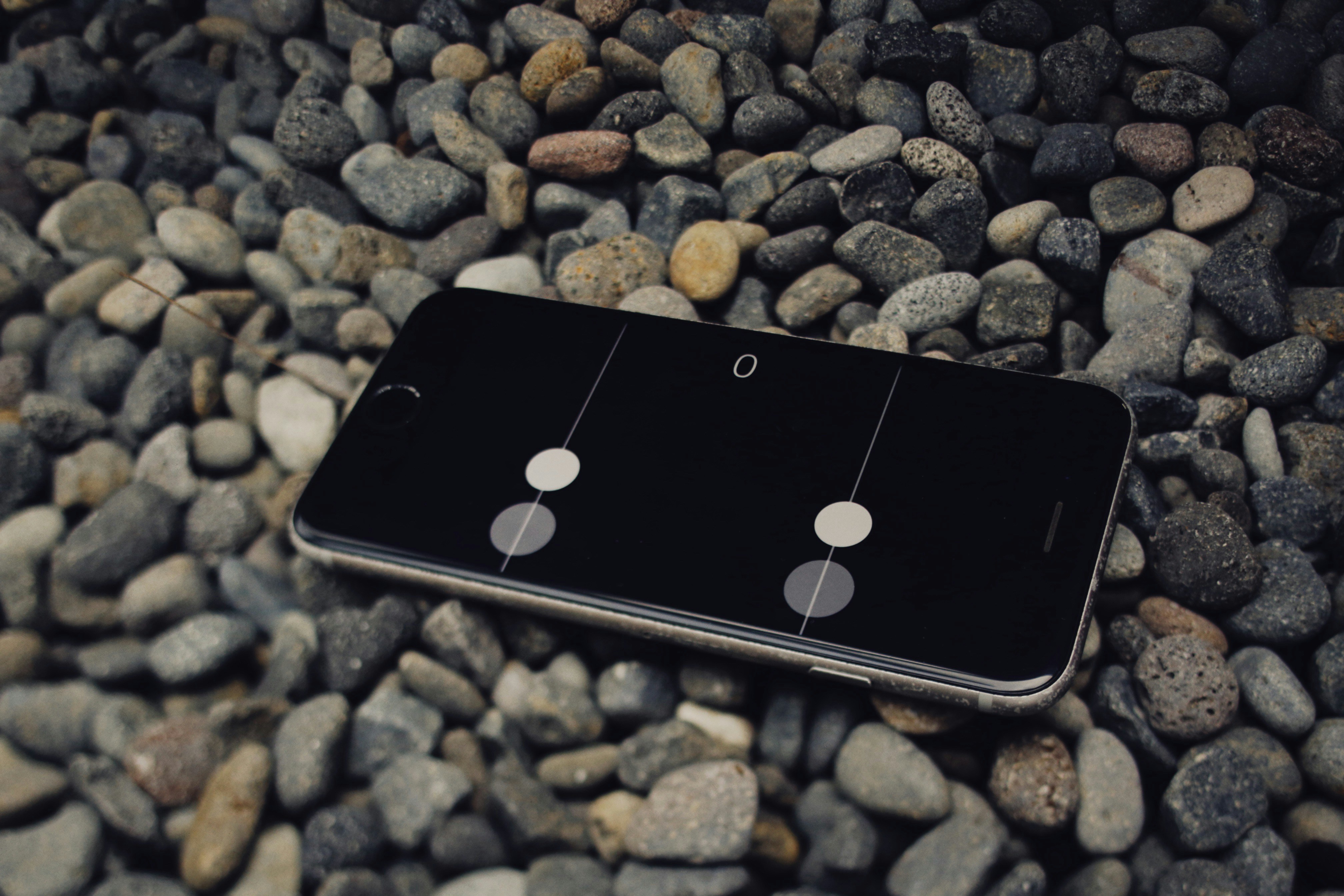 a cell phone laying on top of a pile of rocks