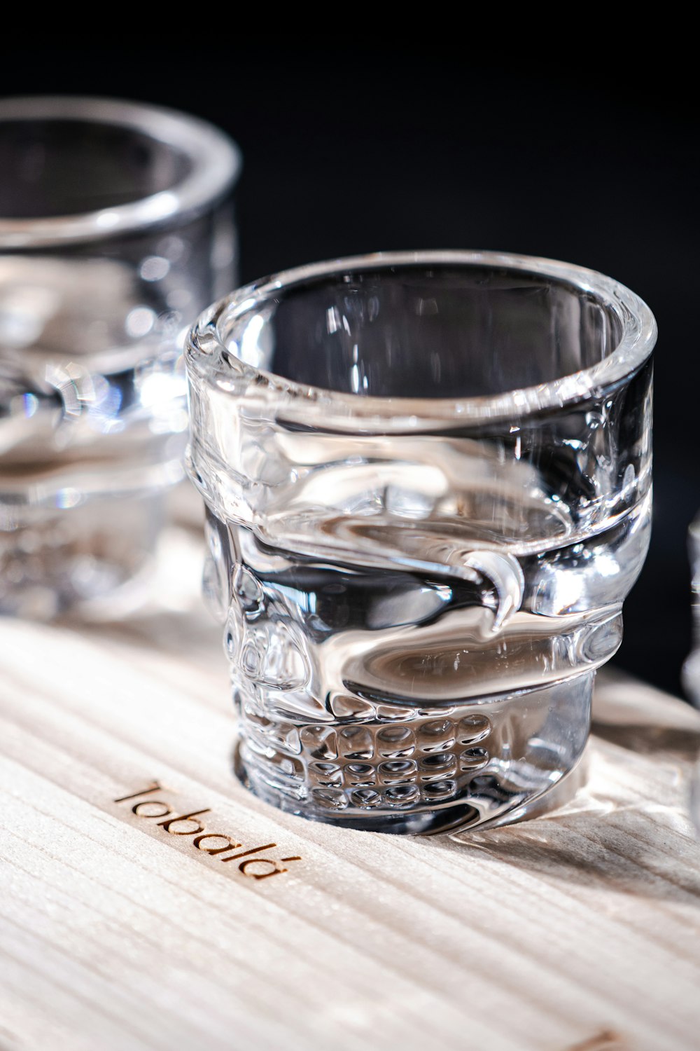 two shot glasses sitting on top of a wooden table