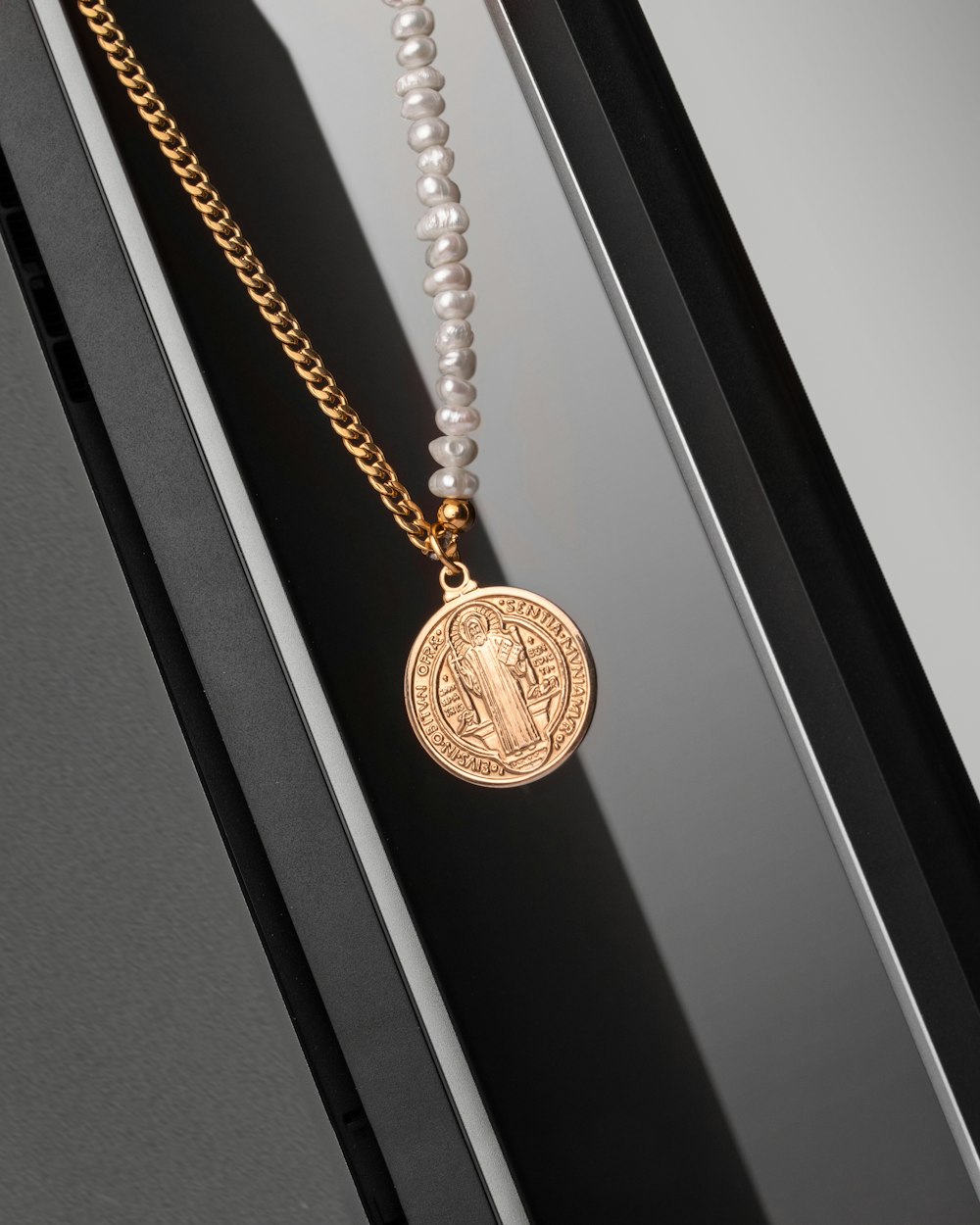 a necklace with a coin on a chain