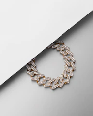 Close-up of a sleek men's gold chain resting on a black velvet surface, highlighting its modern design.