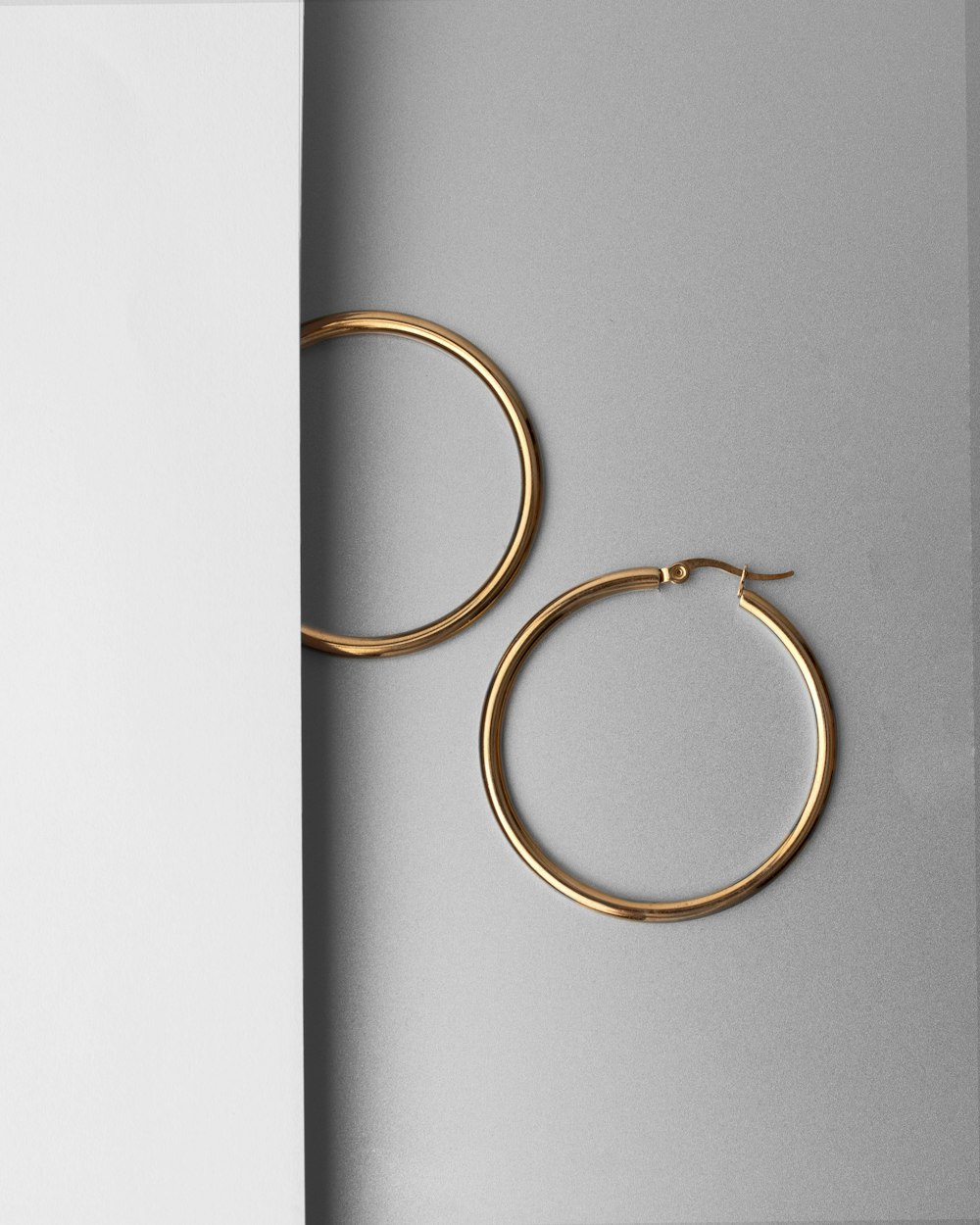 a pair of gold hoop earrings sitting on top of a table