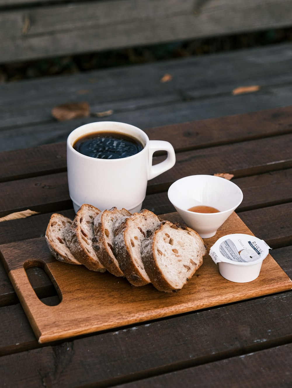 a cup of coffee and some bread on a wooden table