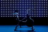 a stationary exercise bike in front of a blue background