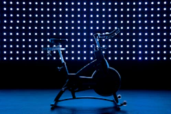 a stationary exercise bike in front of a blue background