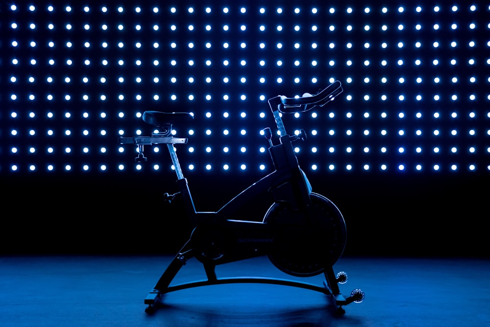 a stationary exercise bike in front of a blue background