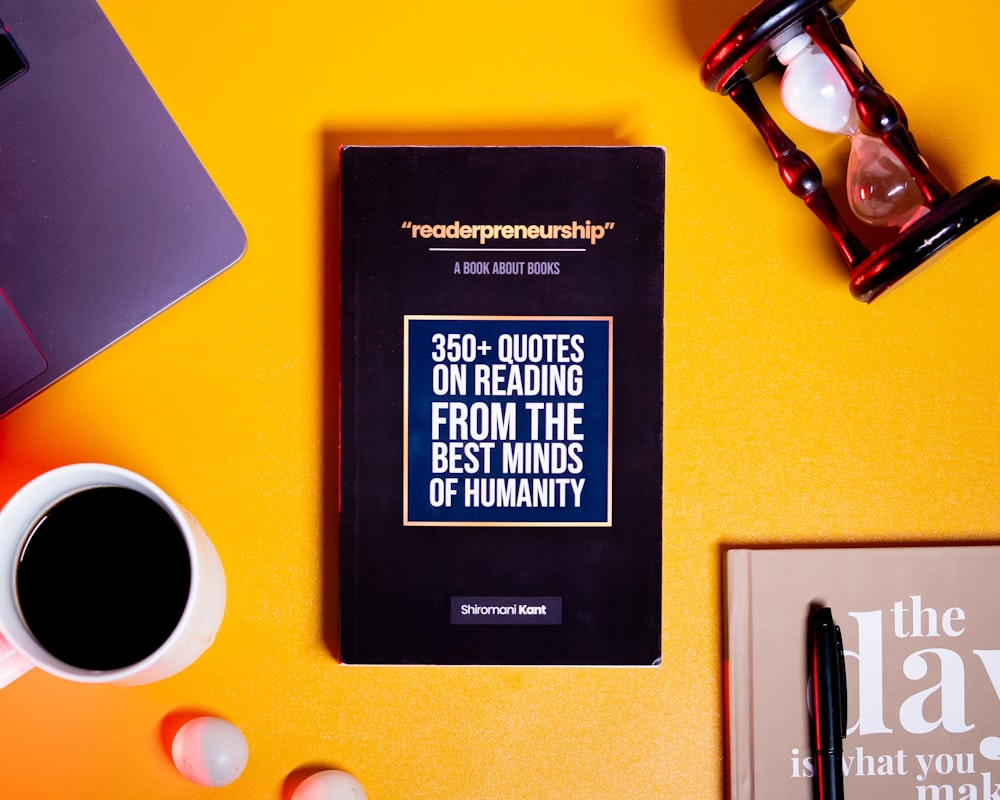 a book sitting on top of a table next to a cup of coffee