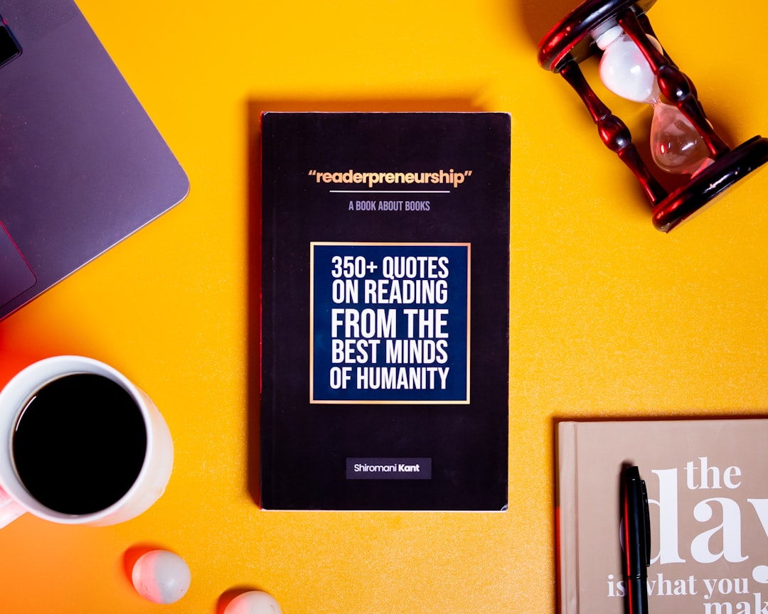 a book sitting on top of a table next to a cup of coffee,