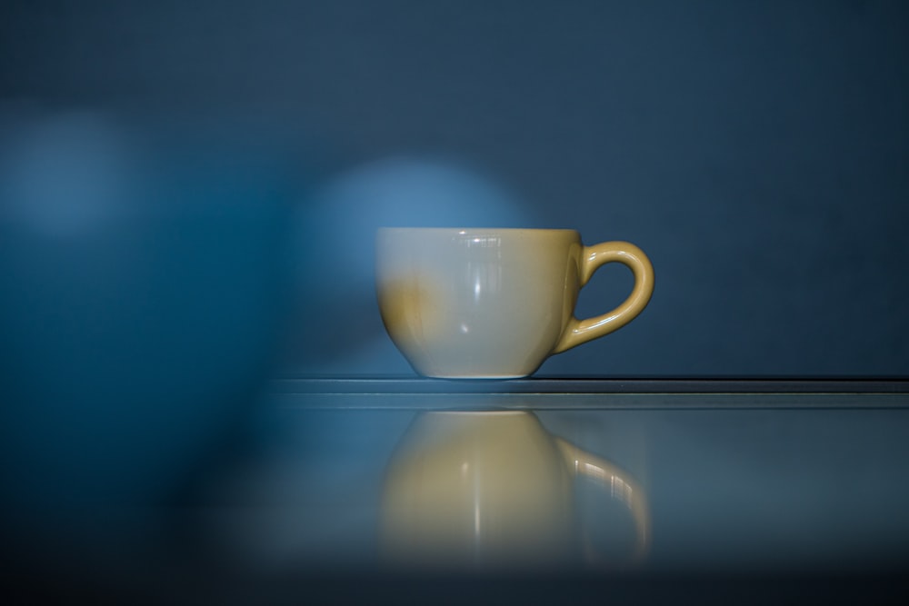 a white coffee cup sitting on top of a table