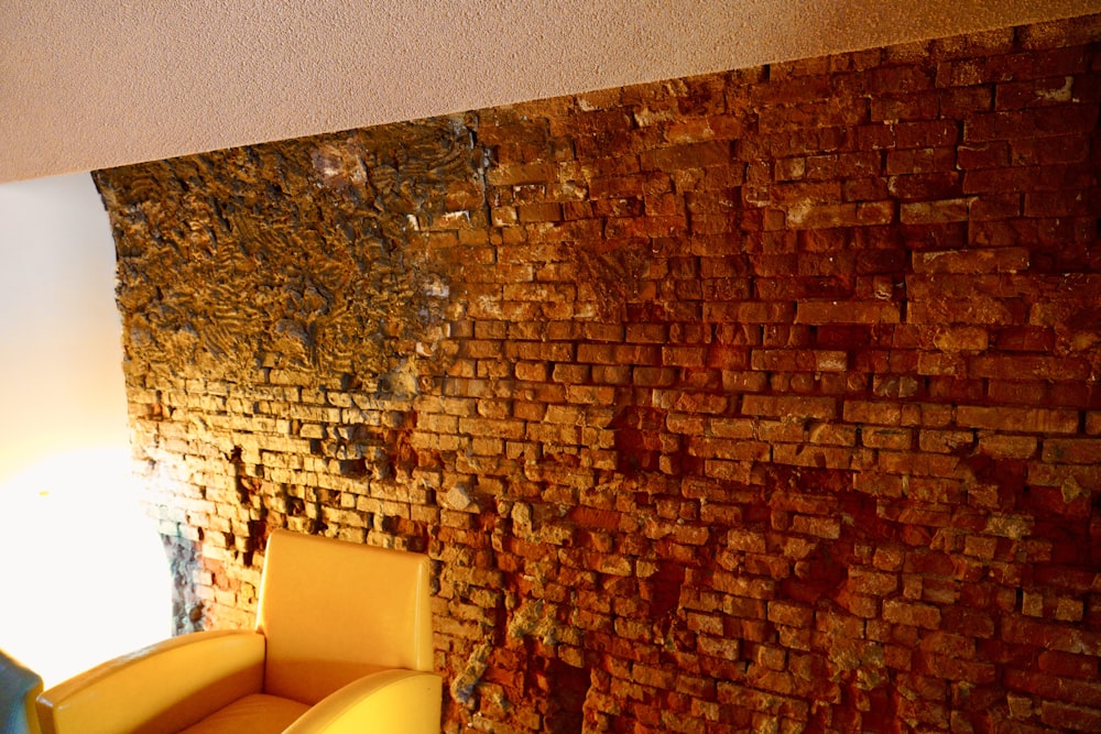 a room with a chair and a brick wall