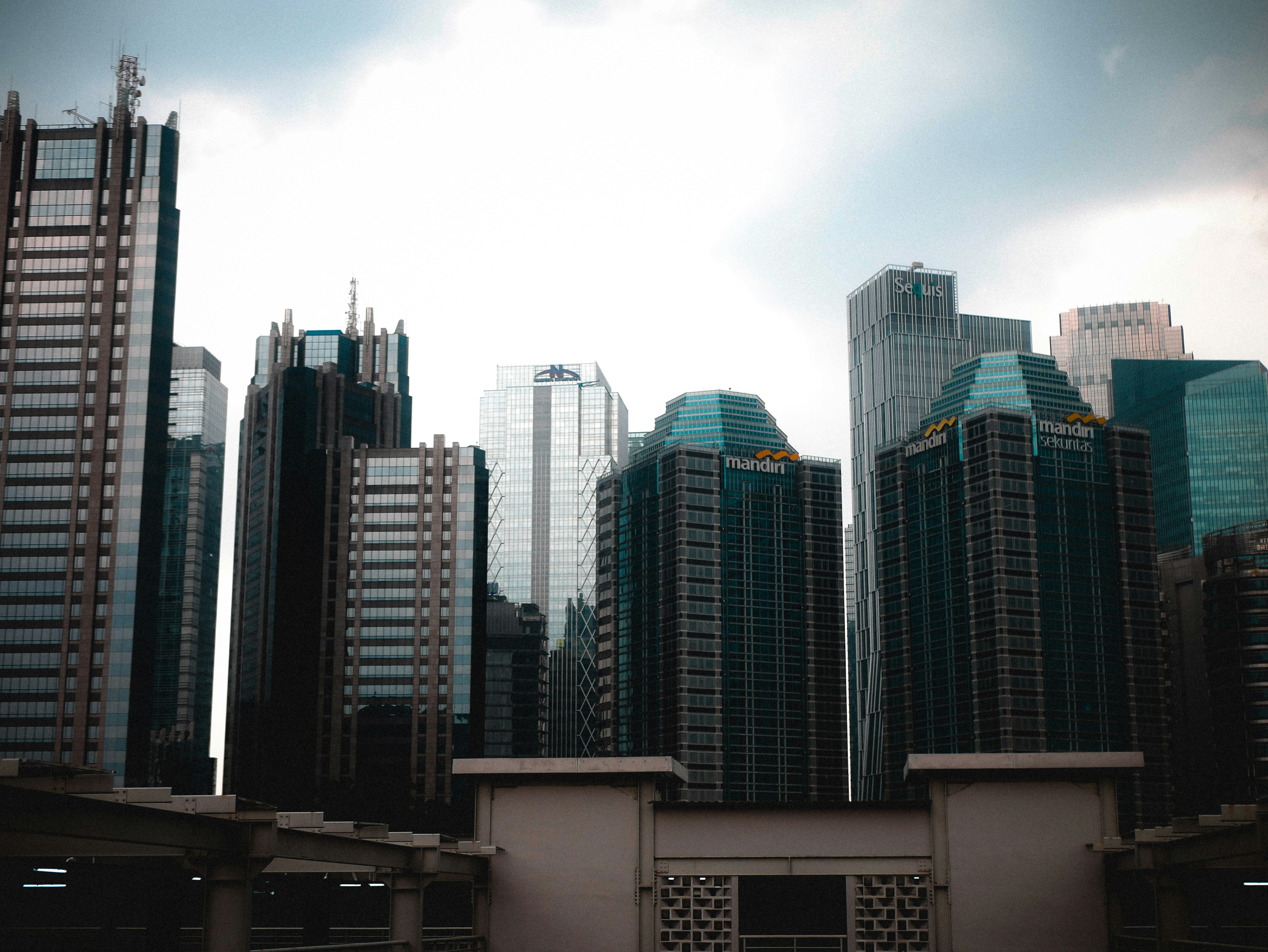 a group of tall buildings in a city, a sunndy day in the middle town