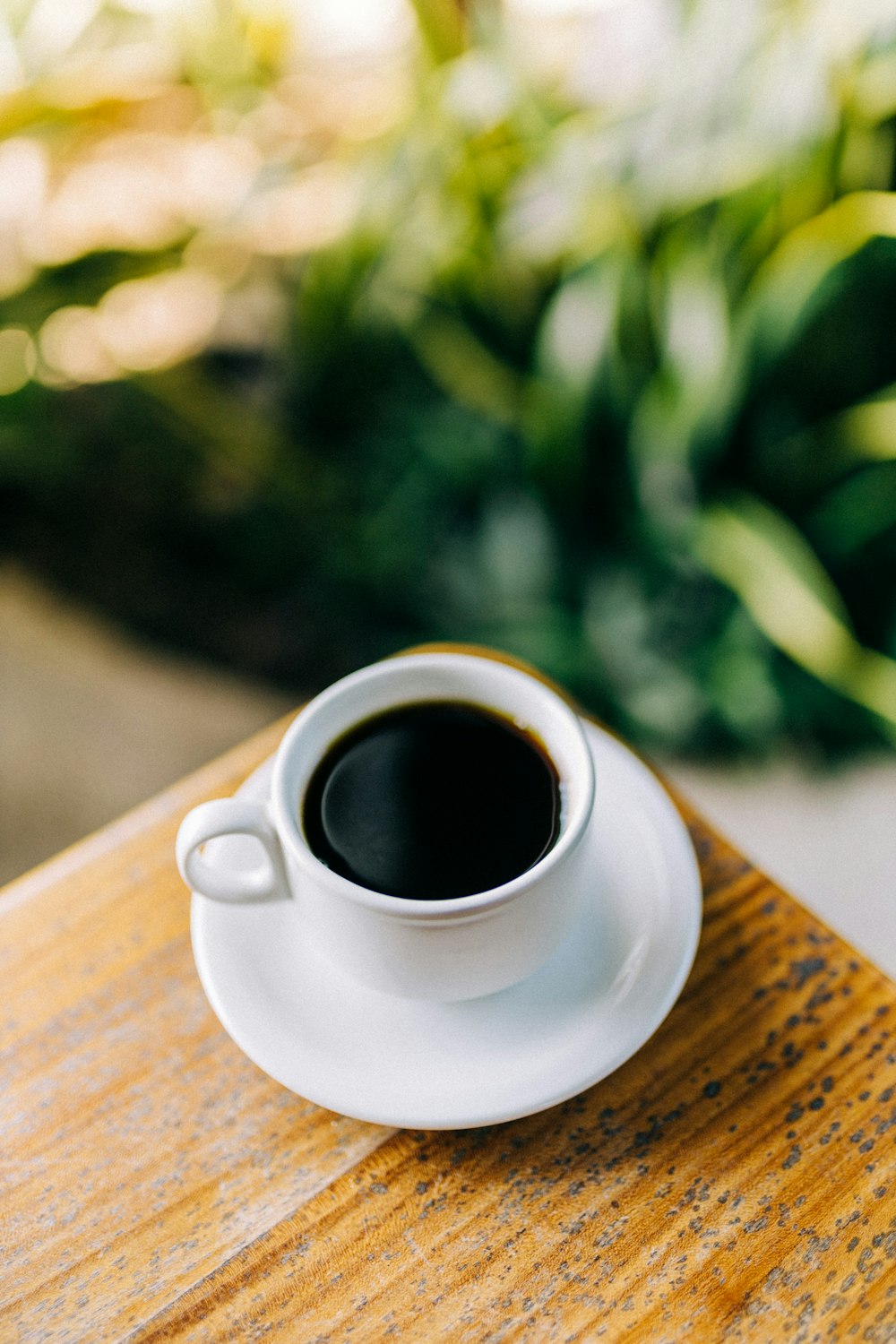 a cup of coffee sitting on top of a wooden table