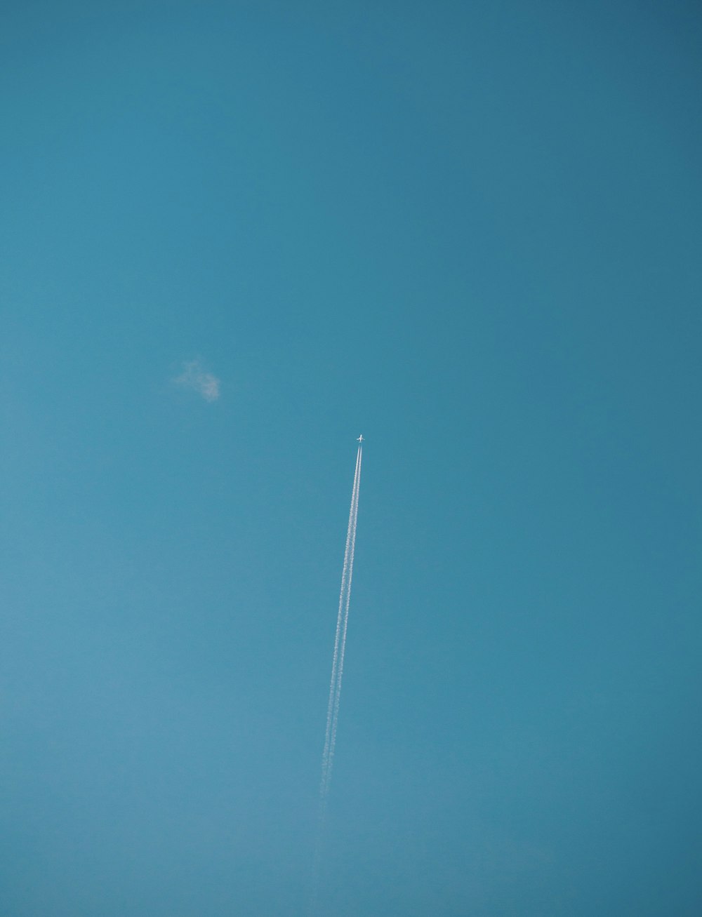 Un avión vuela alto en el cielo