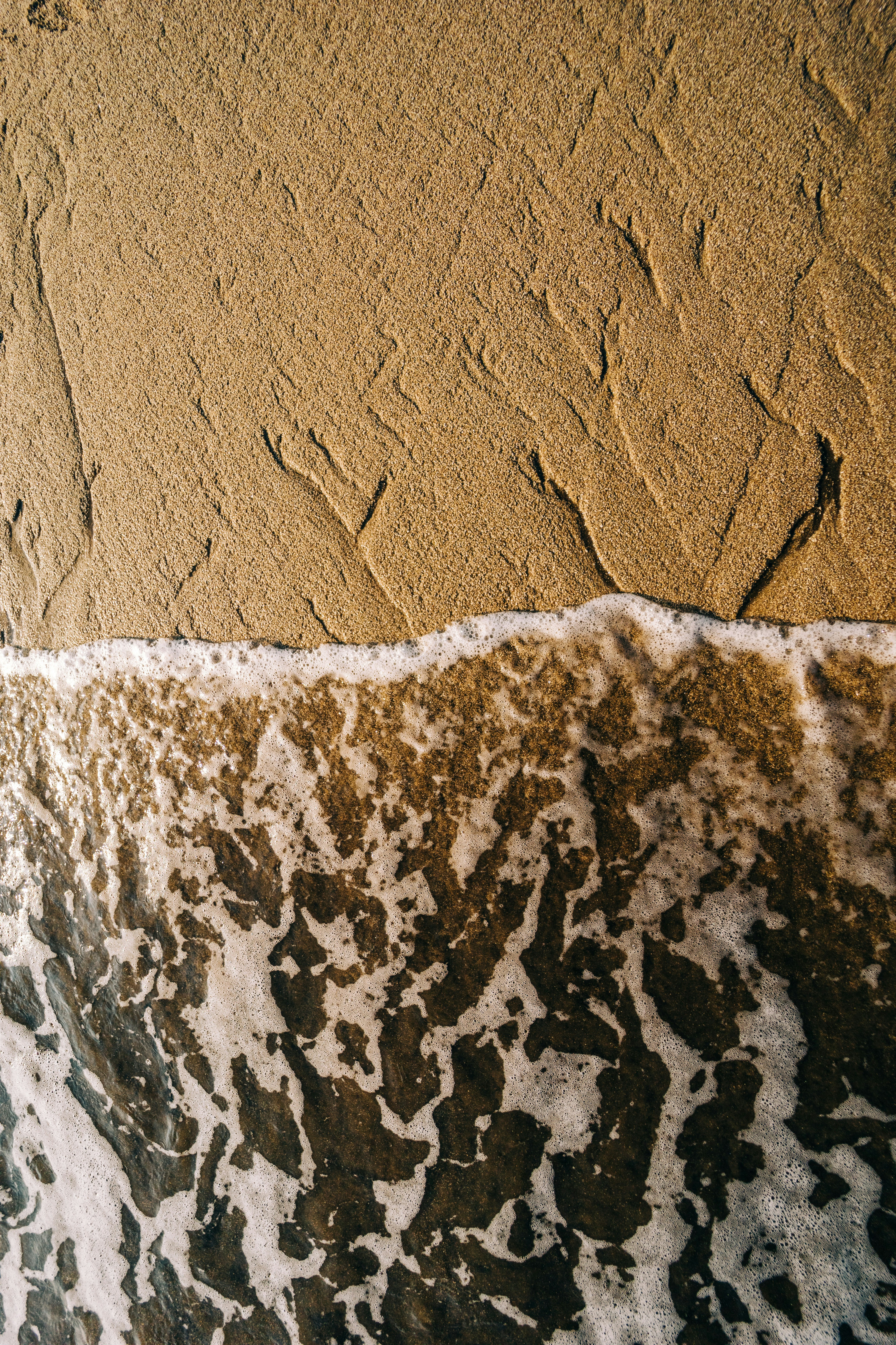 a wave is coming in to the shore of the beach
