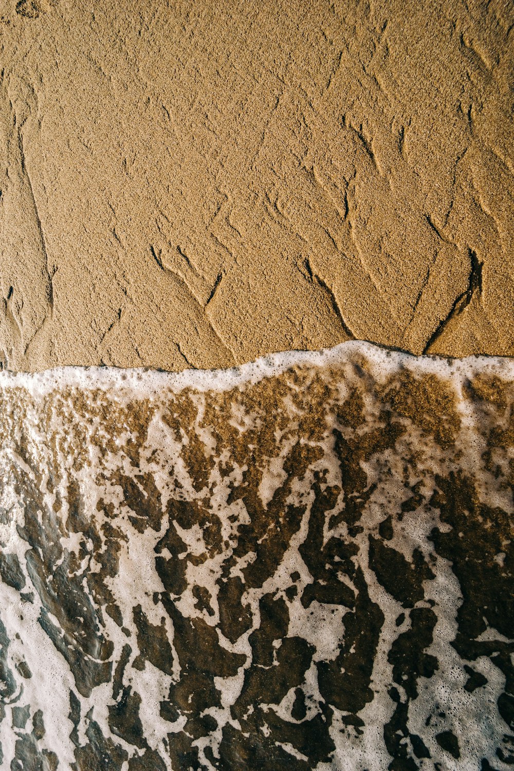 a wave is coming in to the shore of the beach