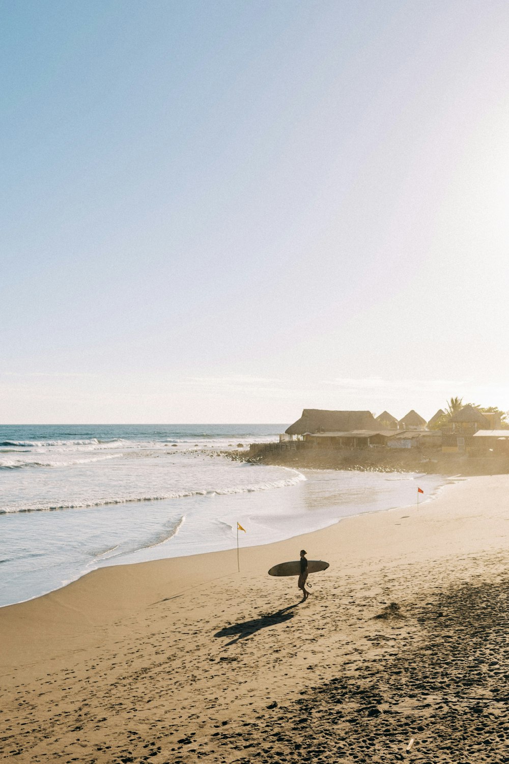 une personne tenant une planche de surf sur une plage