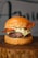 Close-up of a juicy grilled beef patty on a rustic wooden board.